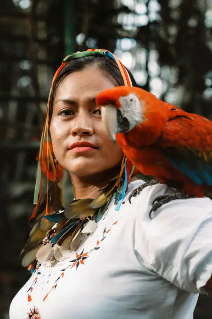 Lenguas de la Amazonía Peruana: Un Viaje en la Conservación de la Comunicación Indígena 26 Mujer con una guacamaya escarlata en el hombro, lenguas de la Amazonía peruana